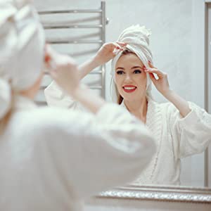 Image of a woman looking blissful as she looks at a mirror]